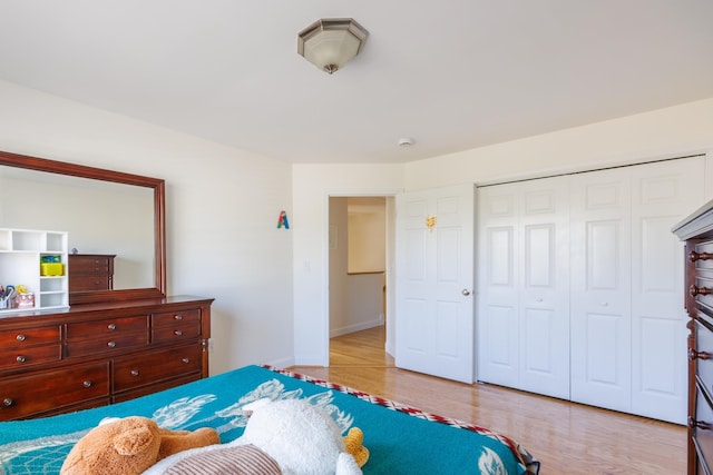 bedroom featuring a closet, baseboards, and light wood-type flooring