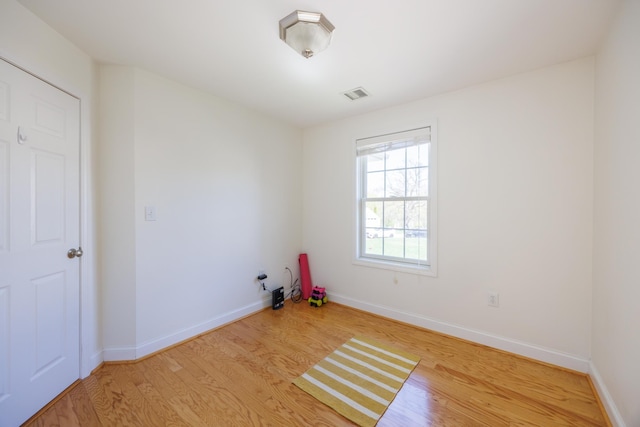 spare room with visible vents, light wood finished floors, and baseboards
