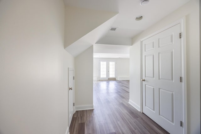 hall featuring baseboards, visible vents, and dark wood-type flooring