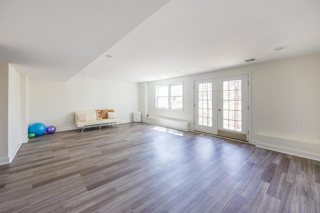 interior space featuring baseboards, wood finished floors, and visible vents