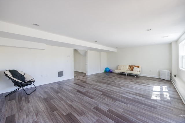 unfurnished room featuring baseboards, wood finished floors, and visible vents