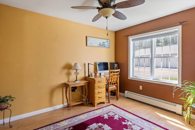 home office featuring baseboards, a ceiling fan, a baseboard heating unit, and wood finished floors