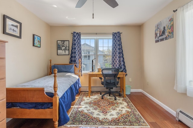 bedroom featuring baseboards, baseboard heating, a ceiling fan, and wood finished floors