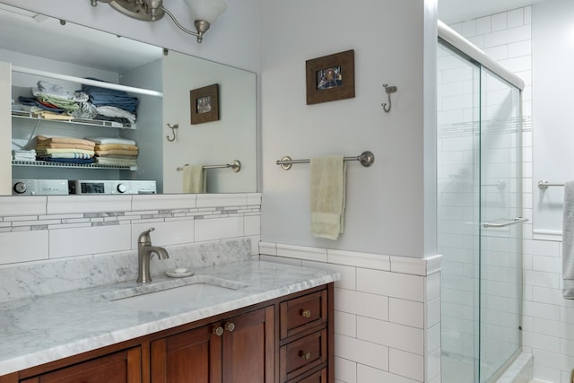 bathroom with vanity, tile walls, and a stall shower