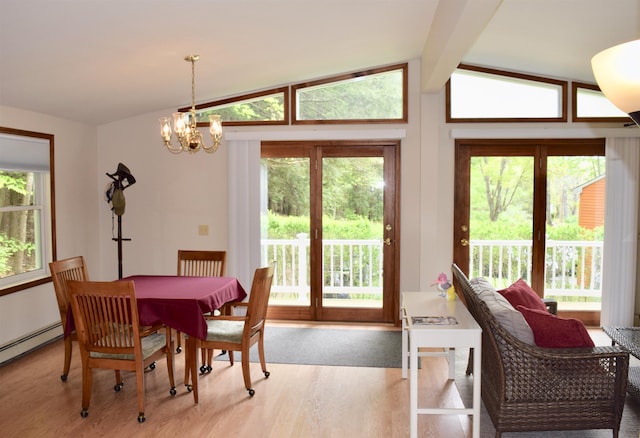 dining area featuring an inviting chandelier, lofted ceiling with beams, wood finished floors, and a wealth of natural light