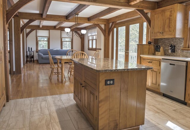 kitchen featuring dishwasher, tasteful backsplash, a kitchen island, beamed ceiling, and pendant lighting