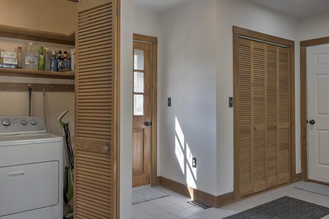 laundry room featuring baseboards, laundry area, washer / dryer, and light tile patterned floors