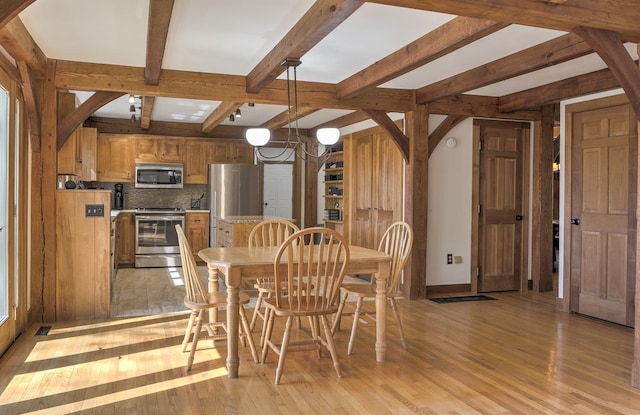 dining room with light wood-style floors, an inviting chandelier, beamed ceiling, and visible vents