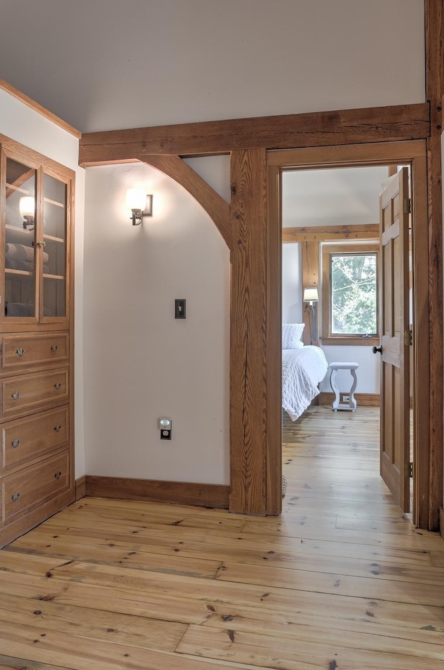 hall with baseboards and light wood-type flooring