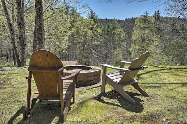 view of yard with a forest view and a fire pit