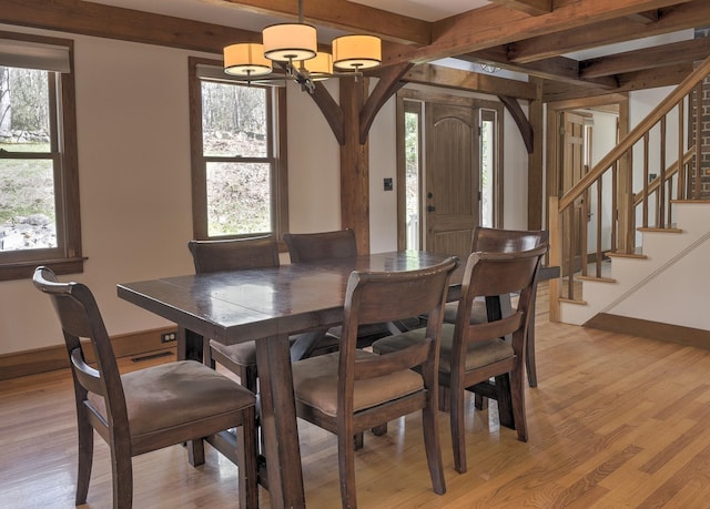dining room with light wood-style flooring, a notable chandelier, and a healthy amount of sunlight