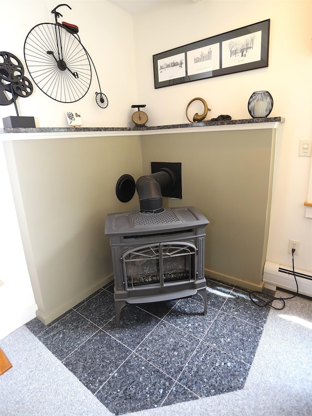 detailed view of a wood stove, baseboards, and baseboard heating