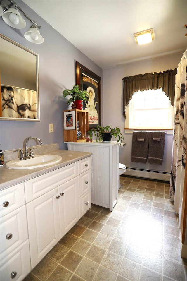 bathroom featuring a baseboard heating unit, toilet, and vanity