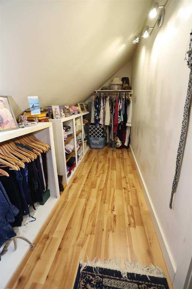 spacious closet with vaulted ceiling and wood finished floors