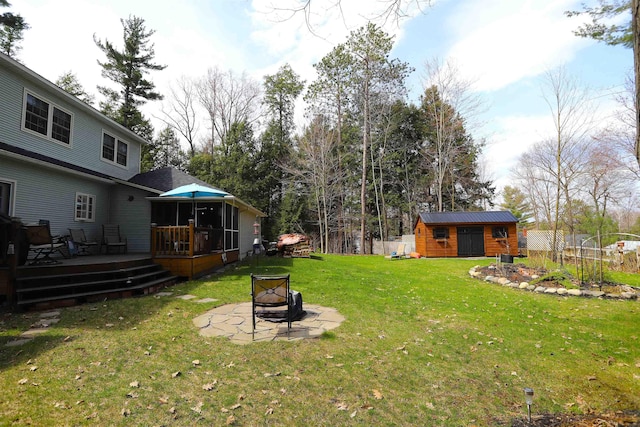 view of yard with an outdoor fire pit, a wooden deck, and an outdoor structure