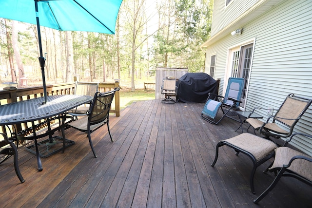 deck featuring outdoor dining space and area for grilling
