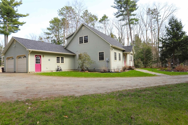 view of side of property with driveway, a garage, a lawn, and a shingled roof