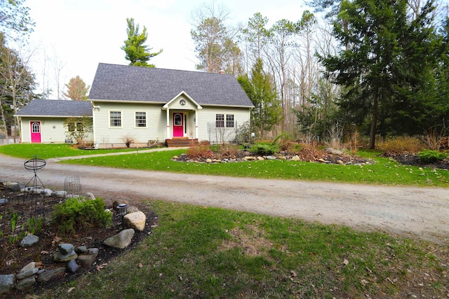 view of front facade featuring a front lawn, a chimney, and a shingled roof