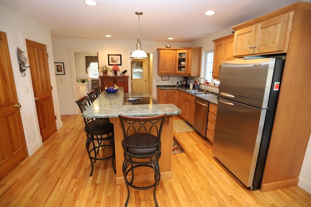 kitchen featuring appliances with stainless steel finishes, a sink, light wood-style flooring, and recessed lighting