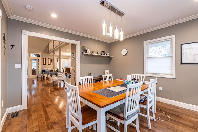 dining space featuring a healthy amount of sunlight, crown molding, and wood finished floors