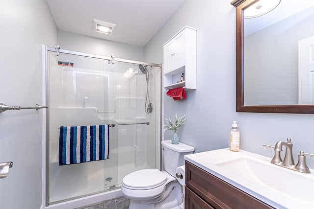 bathroom featuring vanity, a stall shower, and toilet