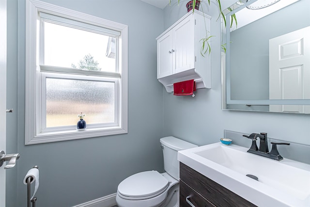 half bathroom featuring vanity and toilet