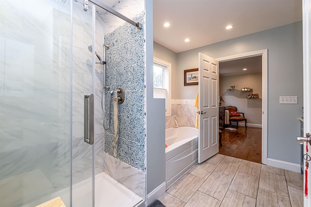 bathroom featuring recessed lighting, wood finished floors, a garden tub, and a stall shower