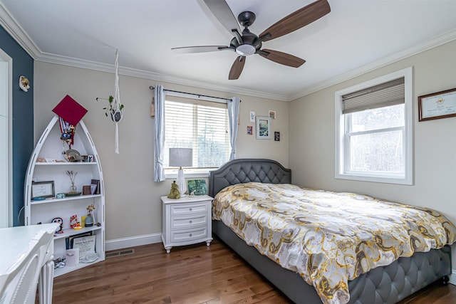 bedroom with crown molding, baseboards, multiple windows, and wood finished floors