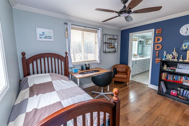 bedroom featuring crown molding, baseboards, wood finished floors, and ensuite bathroom