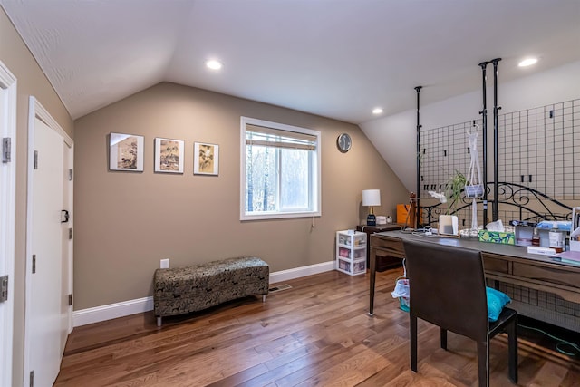 office featuring baseboards, visible vents, wood finished floors, and lofted ceiling