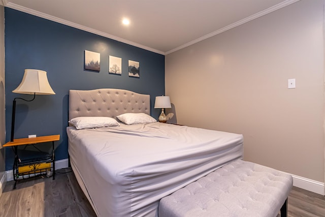 bedroom with baseboards, ornamental molding, and wood finished floors