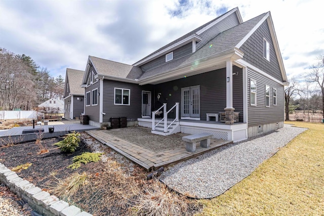 view of front of home featuring roof with shingles, a patio area, french doors, and a deck