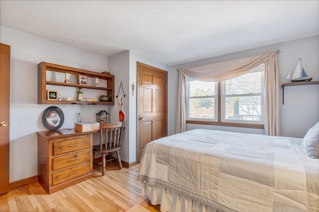 bedroom featuring baseboards and light wood finished floors