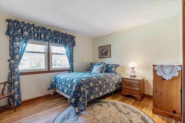 bedroom featuring baseboards and light wood finished floors