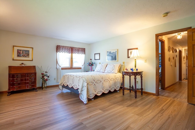 bedroom with baseboards and light wood finished floors