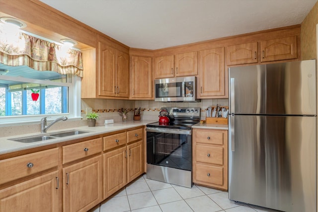 kitchen featuring light countertops, stainless steel appliances, light tile patterned flooring, and a sink