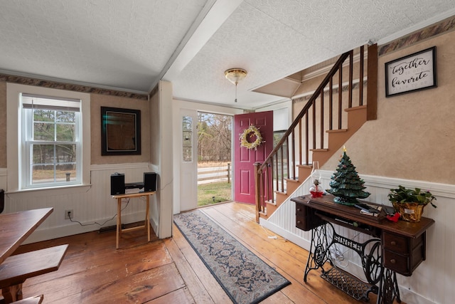 entryway featuring plenty of natural light, wainscoting, and hardwood / wood-style flooring