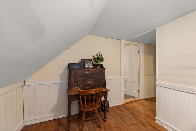 additional living space with wood-type flooring, wainscoting, and lofted ceiling