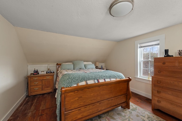 bedroom with baseboards, vaulted ceiling, and hardwood / wood-style floors