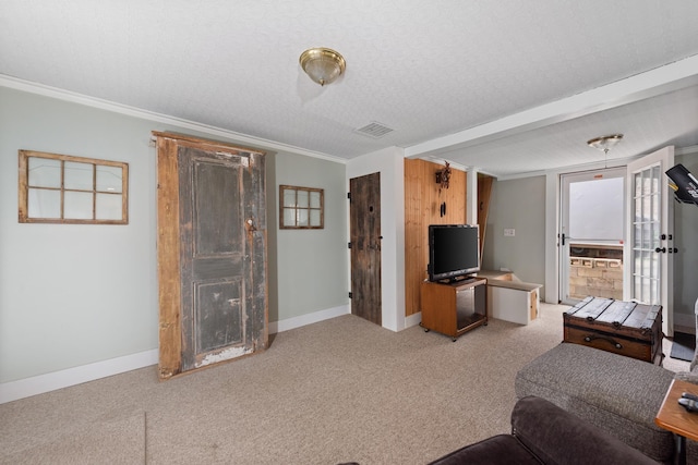 carpeted living area with crown molding, baseboards, and visible vents