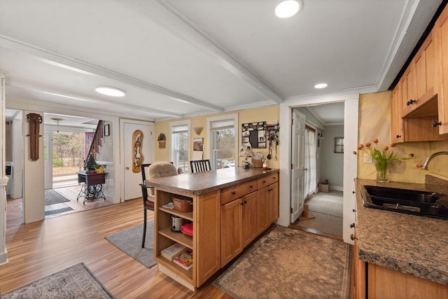 kitchen with dark countertops, open shelves, light wood-type flooring, a sink, and a peninsula