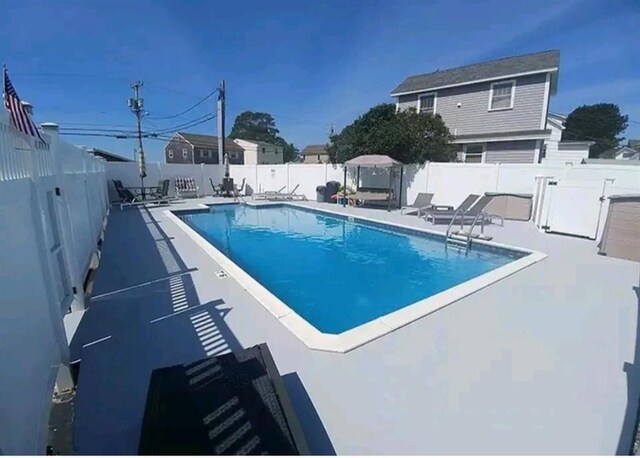 view of swimming pool featuring a fenced backyard and a patio area