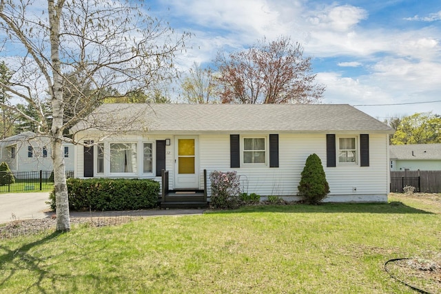 ranch-style home with a front lawn and fence