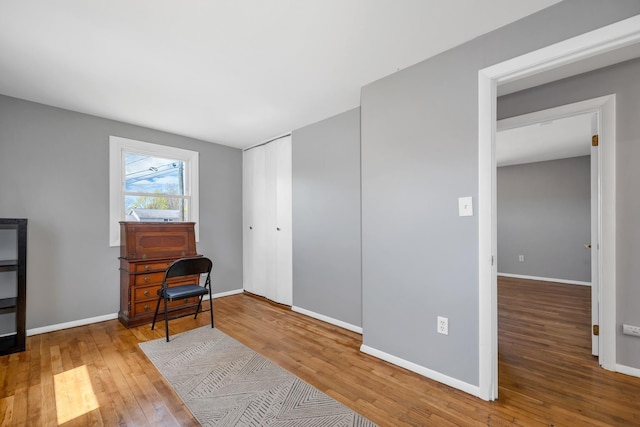 living area featuring baseboards and hardwood / wood-style flooring