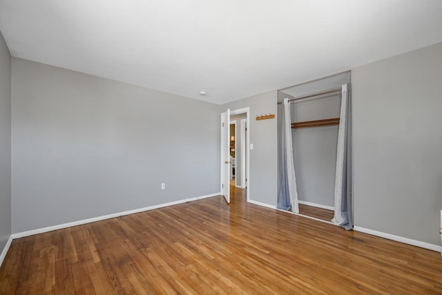unfurnished bedroom featuring baseboards, a closet, and wood finished floors