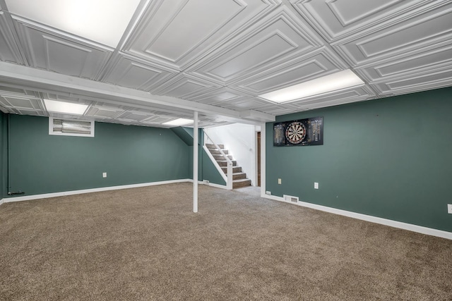 finished below grade area with baseboards, carpet, stairs, and visible vents
