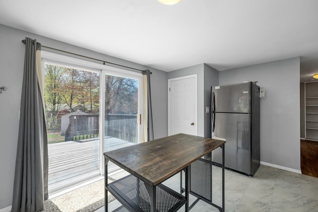 dining space with baseboards and marble finish floor