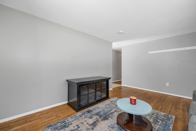 sitting room with baseboards and wood finished floors