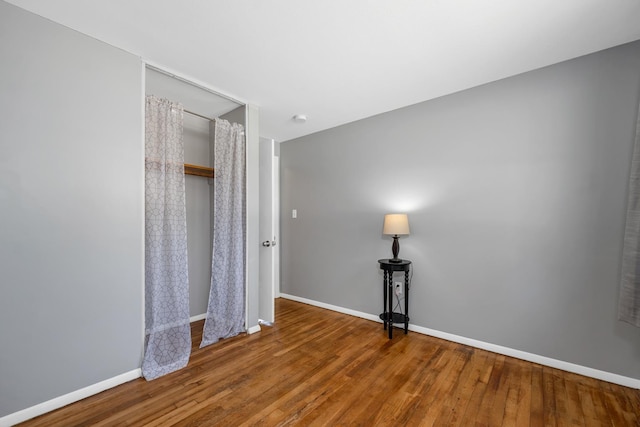 unfurnished bedroom featuring baseboards and wood finished floors