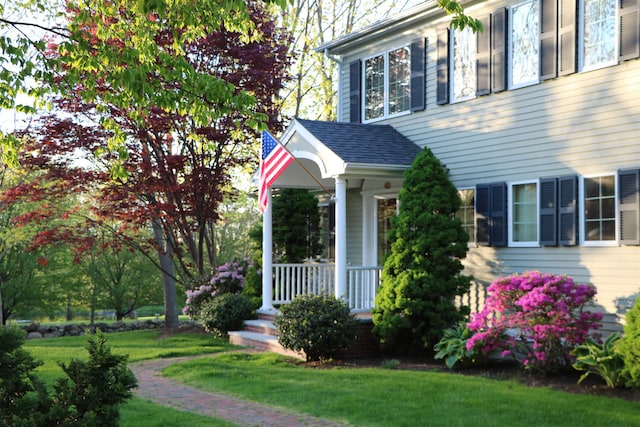 view of front of house featuring covered porch and a front yard
